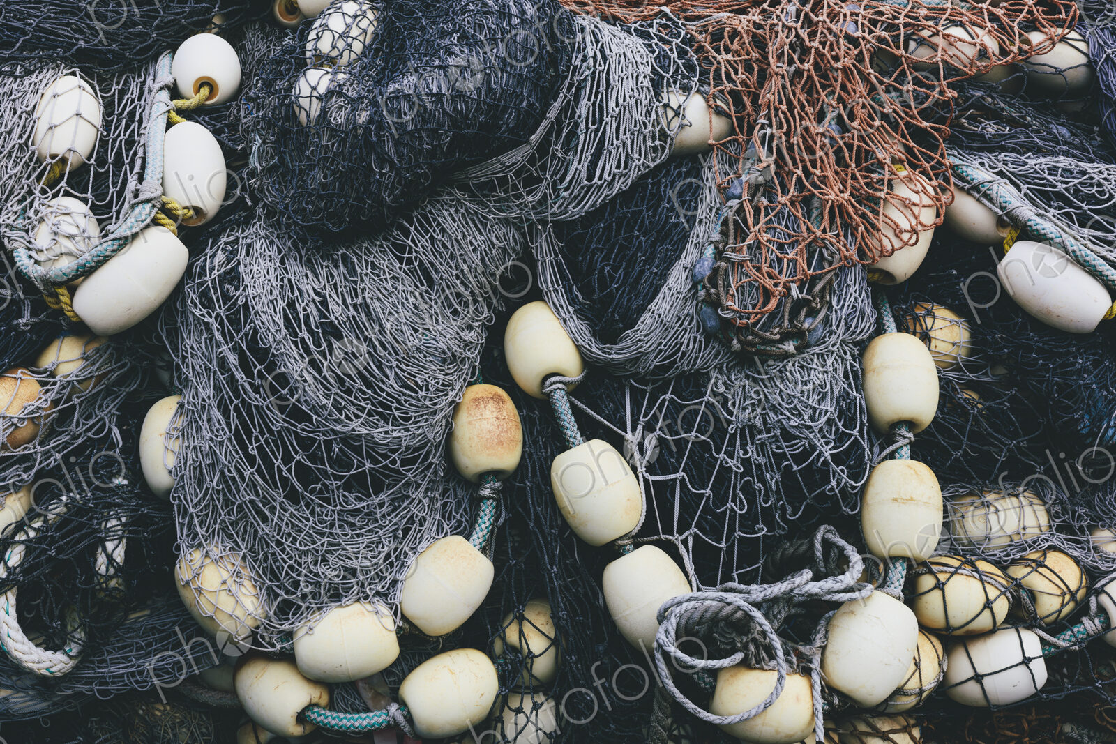 Pile of commercial fishing nets and gill nets on a fishing quay.