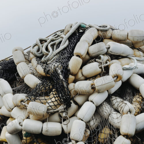 Pile of commercial fishing nets and gill nets on a fishing quay.