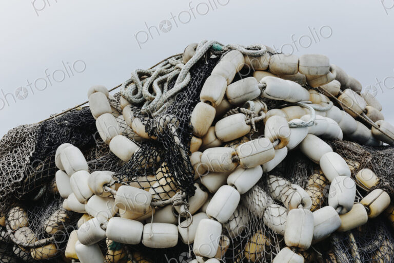 Pile of commercial fishing nets and gill nets on a fishing quay.