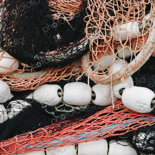 Pile of commercial fishing nets, with white floats, on the quayside at Fisherman's…