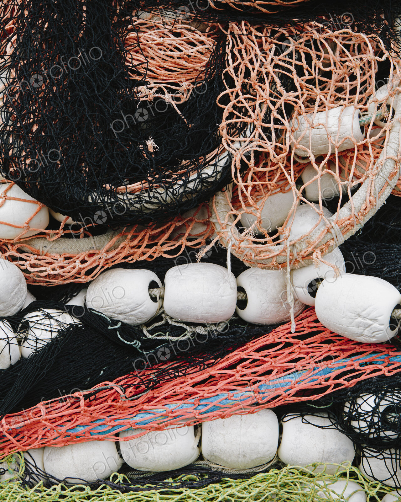 Pile of commercial fishing nets, with white floats, on the quayside at Fisherman’s…