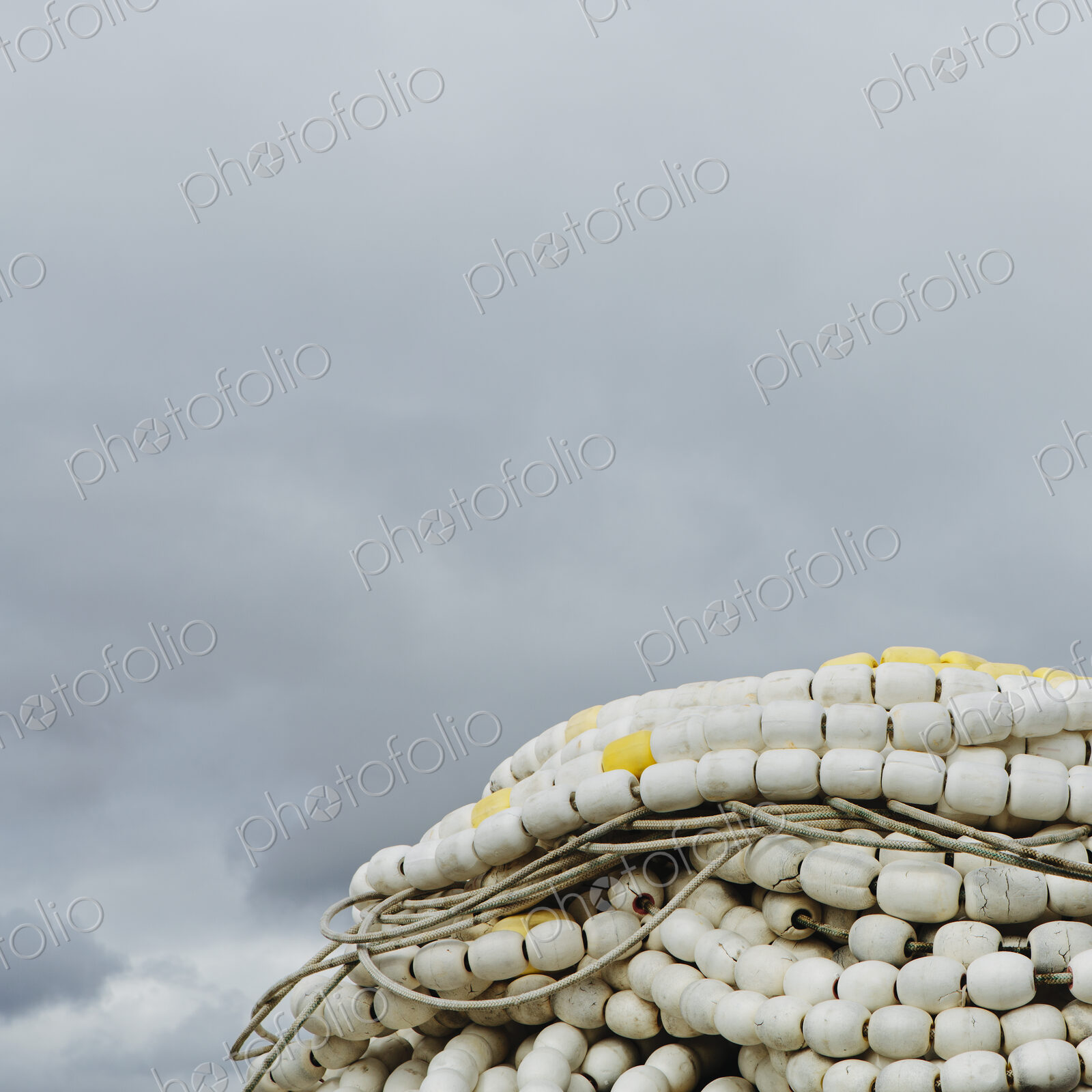 Pile of commercial fishing nets, with white floats, on the quayside at Fisherman’s…
