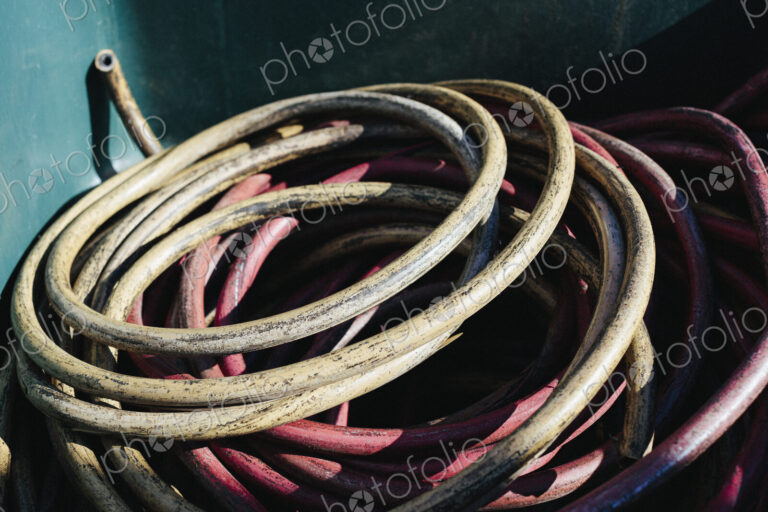 Pile of discarded industrial tubing, coiled in recycling container