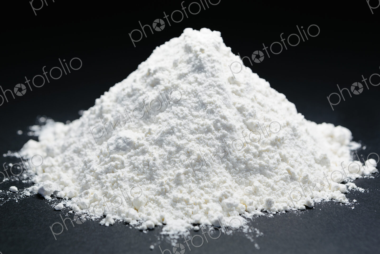 Pile of organic unbleached white flour, black backdrop