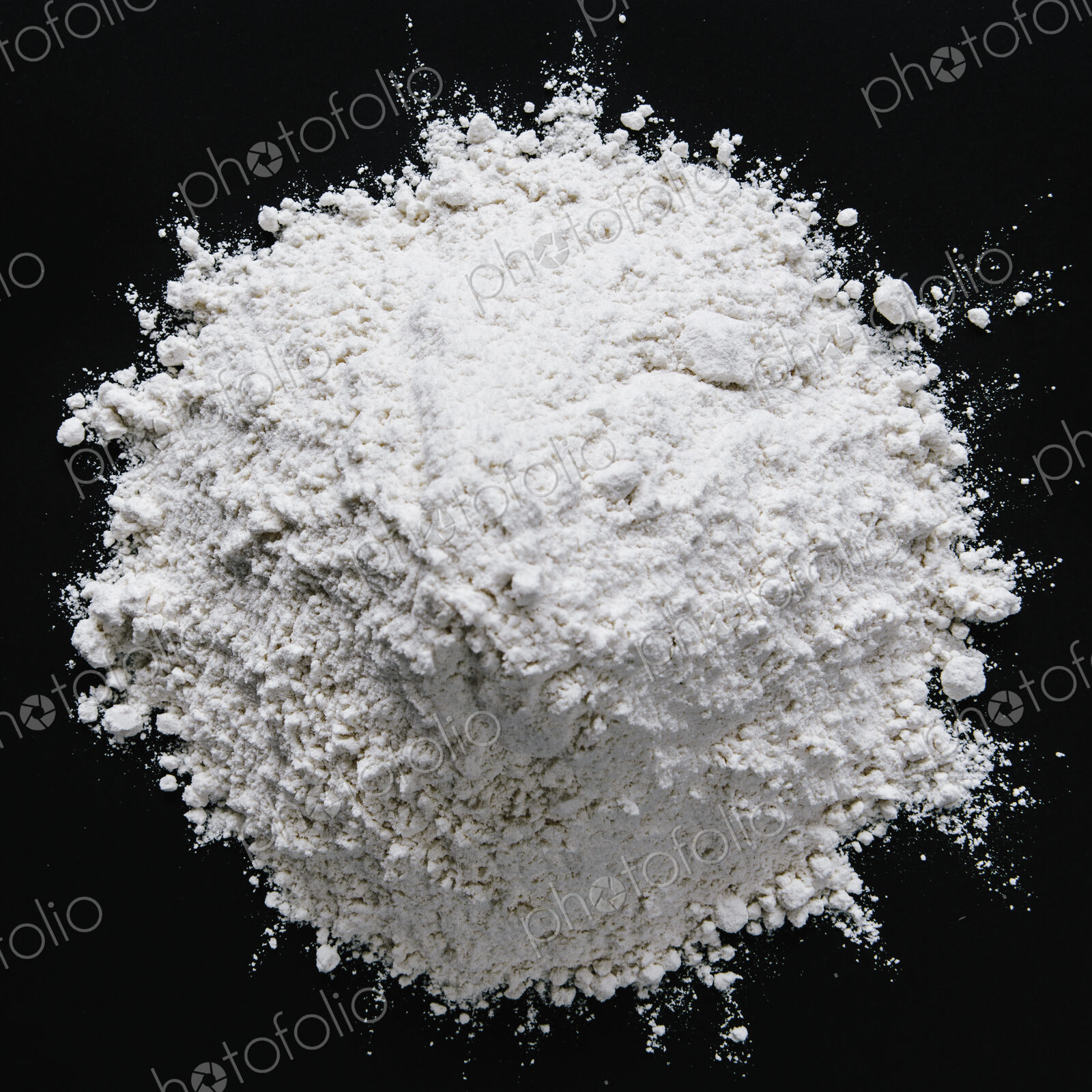 Pile of organic unbleached white flour, black backdrop