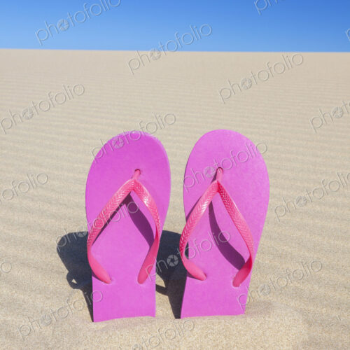 Pink flip flops in sand Pink flip flops in sand