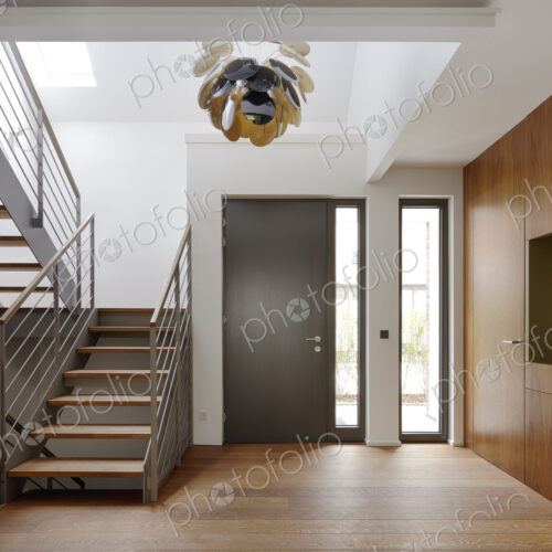 Plank floor and walnut wall covering in home near staircase Plank floor and walnut wall covering in home near staircase