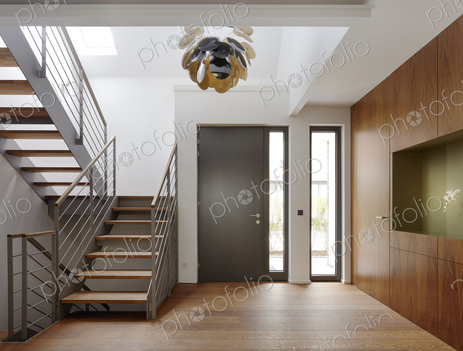 Plank floor and walnut wall covering in home near staircase