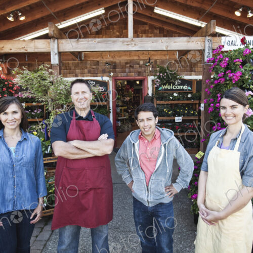 Plant nursery store owners and employees standing in a row in front the store. Plant nursery store owners and employees standing in a row in front the store.
