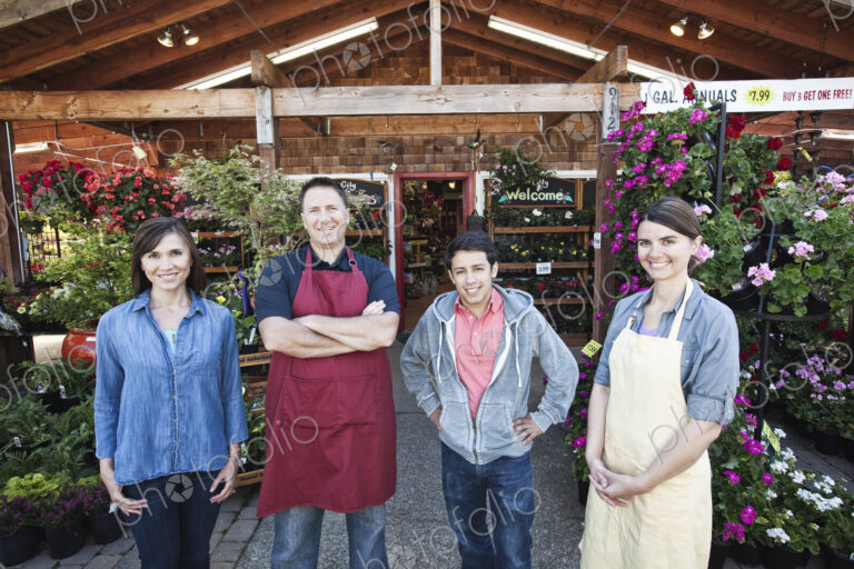 Plant nursery store owners and employees standing in a row in front the store.