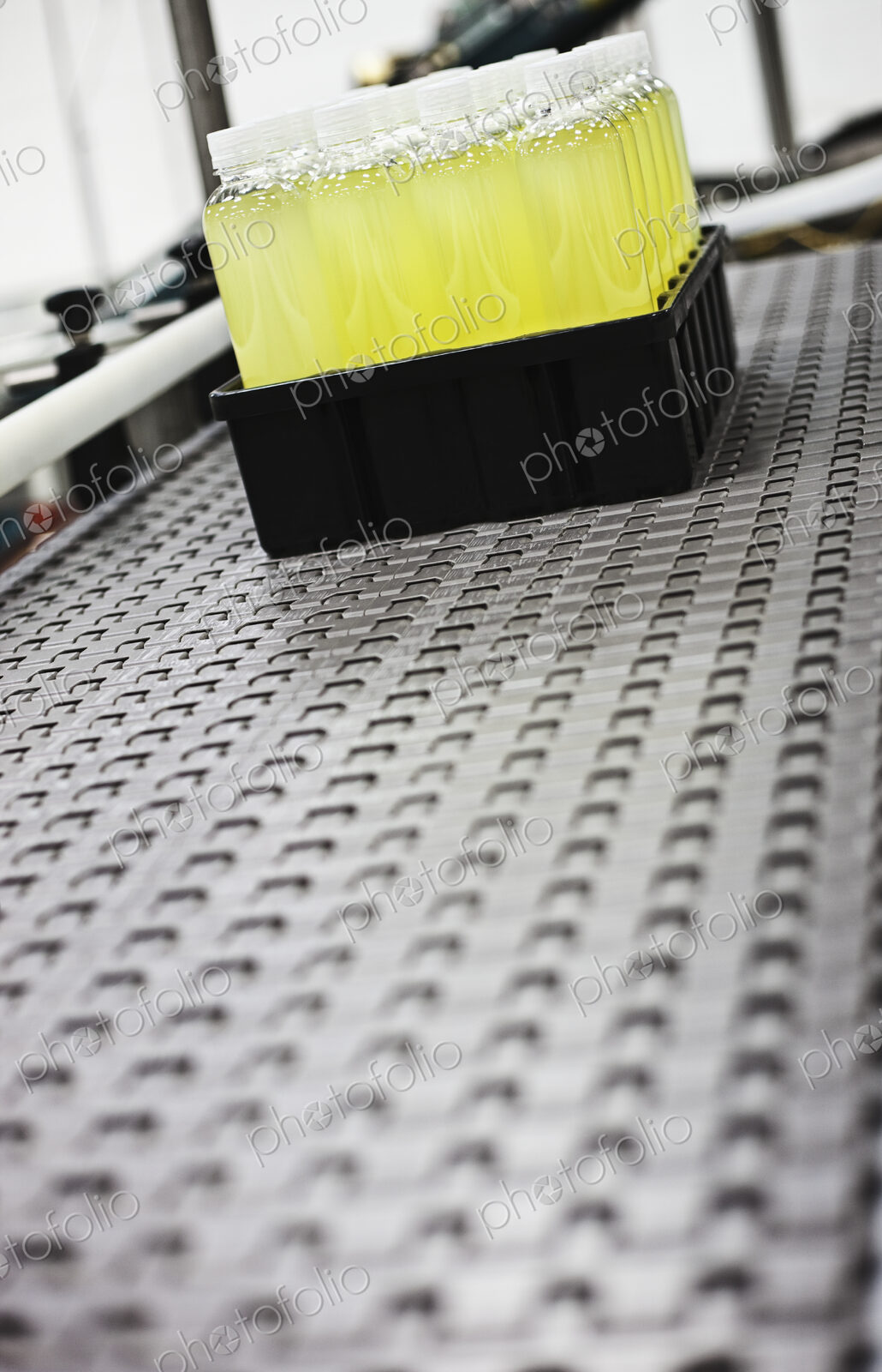 Plastic bottles on conveyor belt in packaging and processing plant.