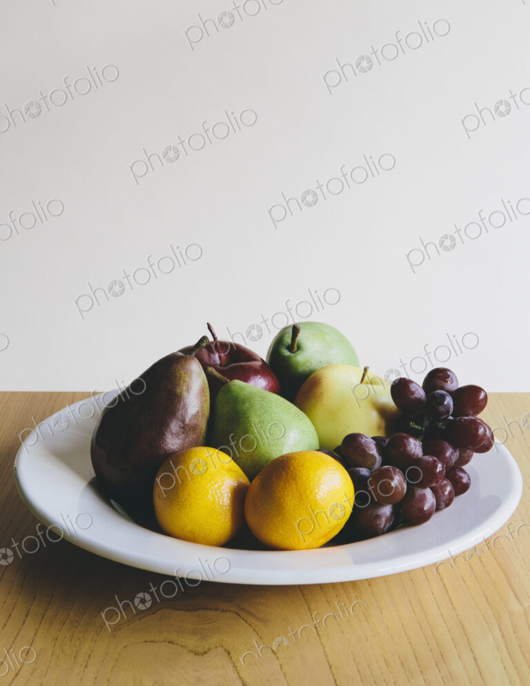 Plate of organic fresh fruit (tangerines, grapes, red bartlett pear, green anjou pears…
