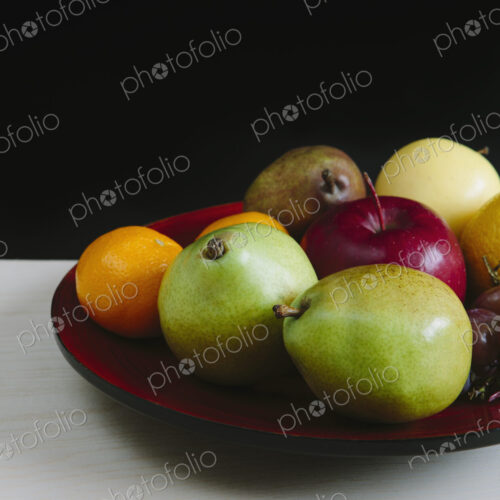 Plate of organic fresh fruit (tangerines, grapes, red bartlett pear, green anjou pears…