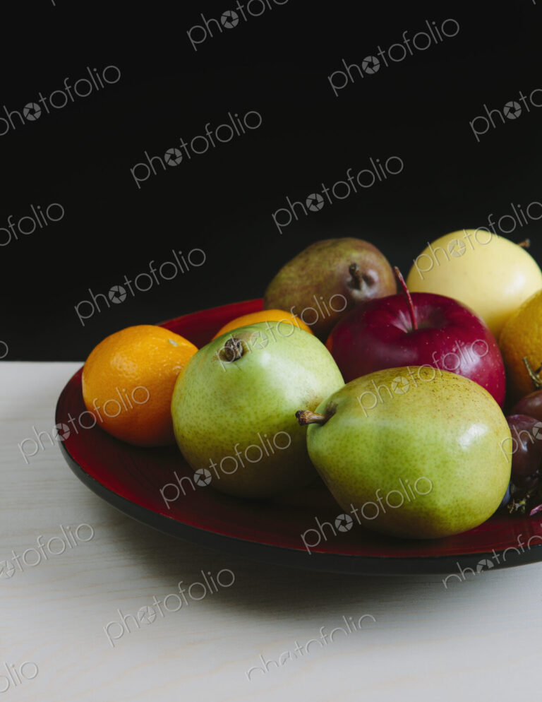 Plate of organic fresh fruit (tangerines, grapes, red bartlett pear, green anjou pears…
