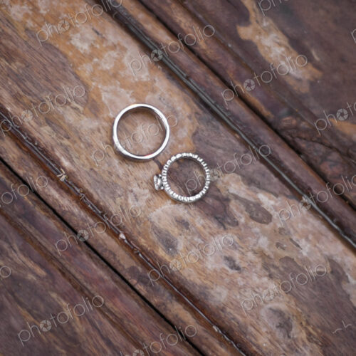 Platinum wedding rings . Two rings on a worn scrubbed stained wooden surface.
