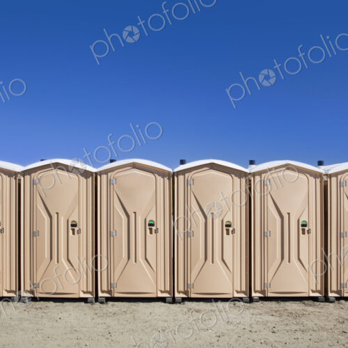 Portable toilets at the beach, in a row. Portable toilets at the beach, in a row.