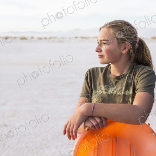 Portrait of 13 year old girl leaning on orange sled, White Sands Nat'l Monument, NM Portrait of 13 year old girl leaning on orange sled, White Sands Nat'l Monument, NM
