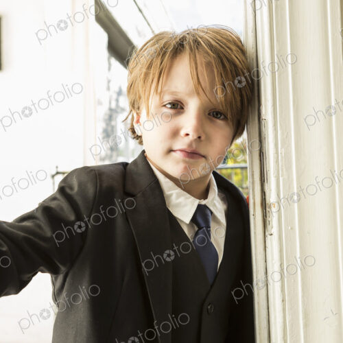 Portrait of 6 year old boy opening a door