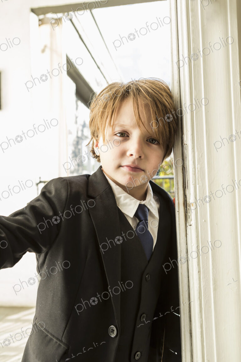 Portrait of 6 year old boy opening a door