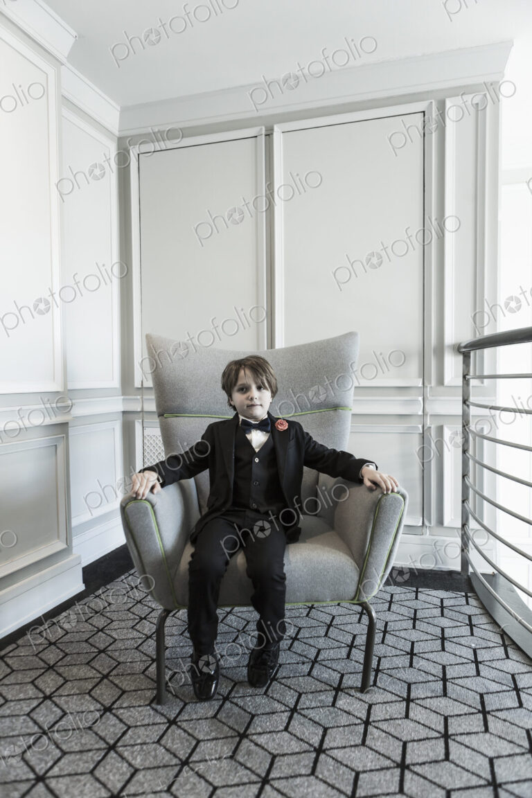 Portrait of 6 year old boy sitting in chair