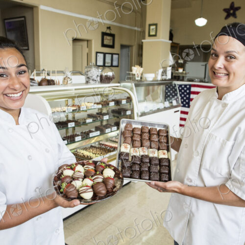 Portrait of Caucasian woman and Hispanic woman co-owners of a candy shop. Portrait of Caucasian woman and Hispanic woman co-owners of a candy shop.