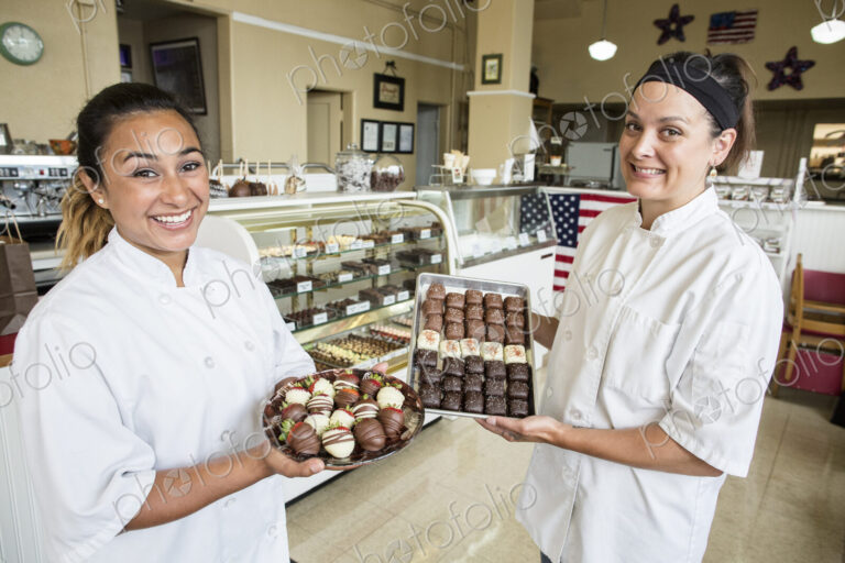 Portrait of Caucasian woman and Hispanic woman co-owners of a candy shop.
