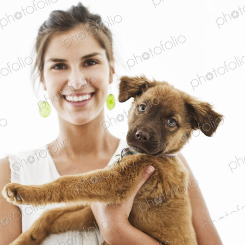 Portrait of Hispanic woman at home with her mixed breed puppy. Portrait of Hispanic woman at home with her mixed breed puppy.