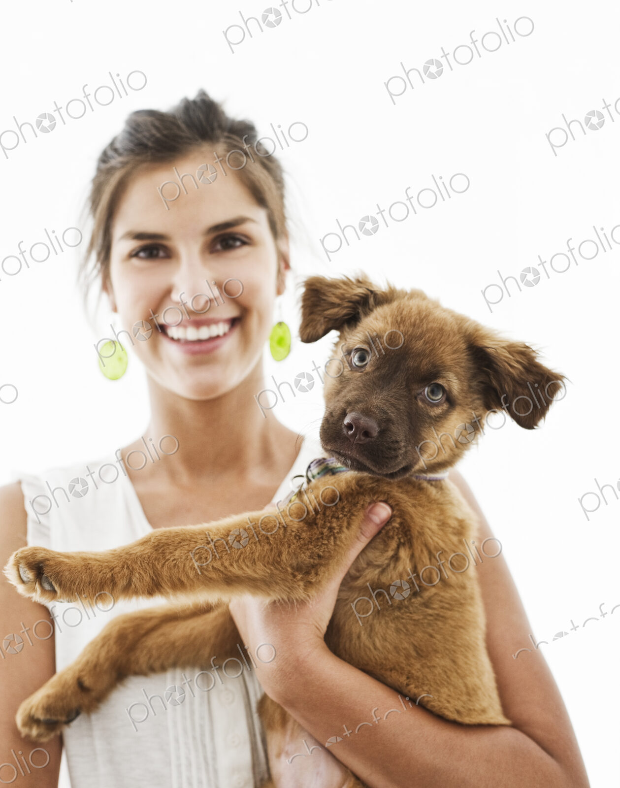 Portrait of Hispanic woman at home with her mixed breed puppy.