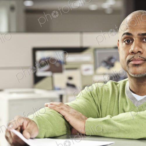 Portrait of a Black man in his cubicle office. Portrait of a Black man in his cubicle office.