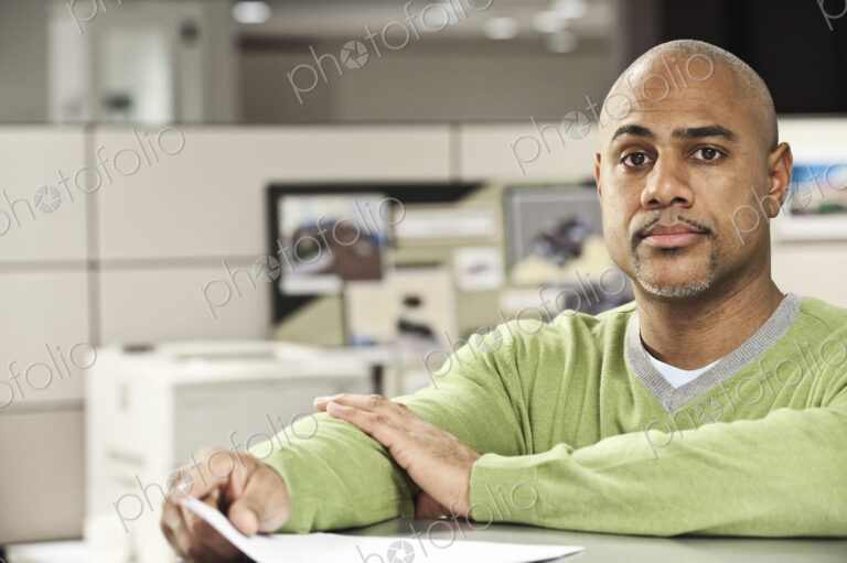 Portrait of a Black man in his cubicle office.