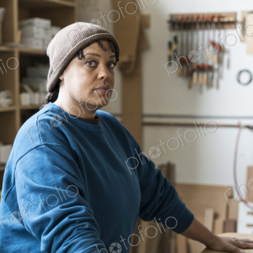 Portrait of a Black woman carpenter in a large woodworking shop. Portrait of a Black woman carpenter in a large woodworking shop.