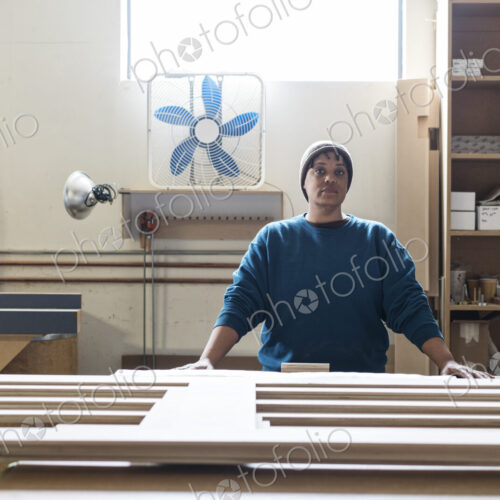 Portrait of a Black woman carpenter in a large woodworking shop. Portrait of a Black woman carpenter in a large woodworking shop.