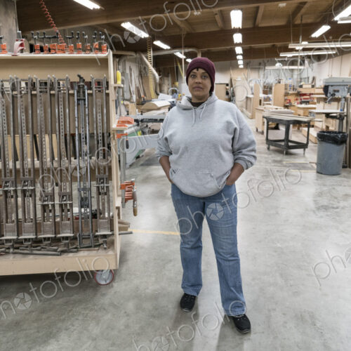 Portrait of a Black woman carpenter in a large woodworking shop. Portrait of a Black woman carpenter in a large woodworking shop.