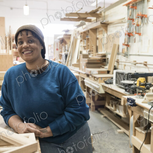 Portrait of a Black woman carpenter in a large woodworking shop. Portrait of a Black woman carpenter in a large woodworking shop.