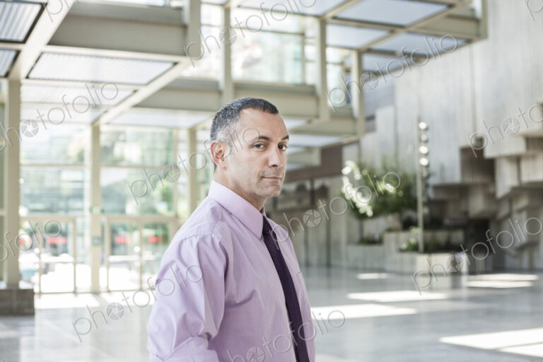 Portrait of a Caucasian businessman in the lobby of a convention center.