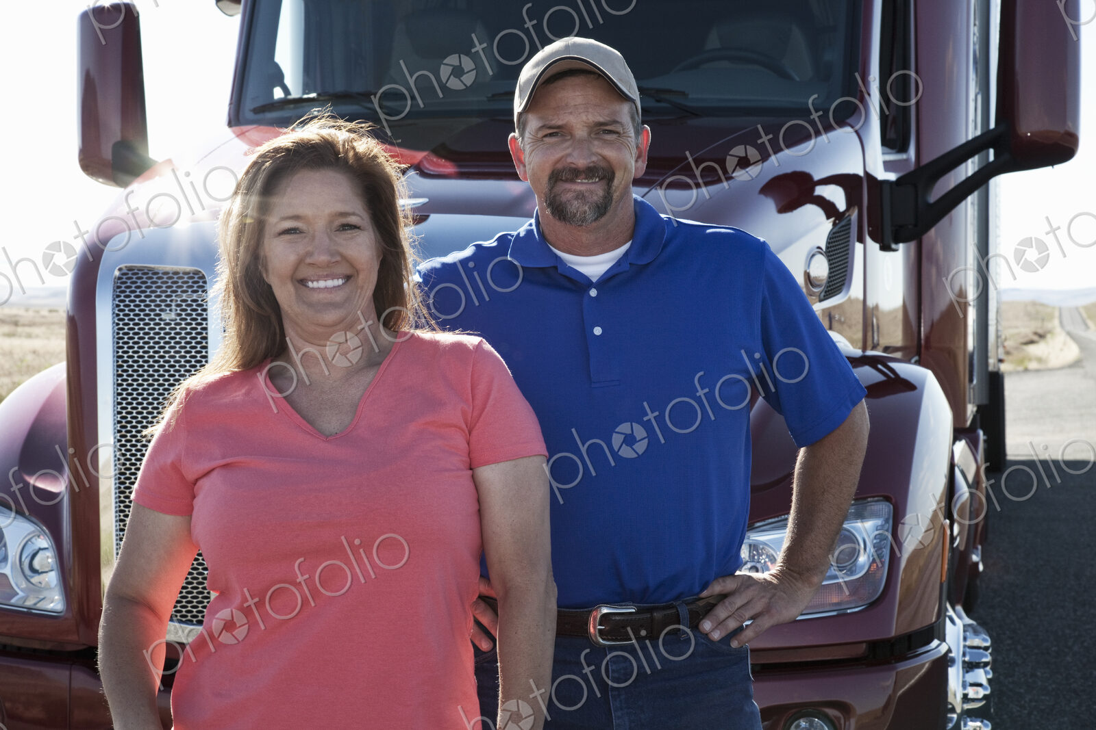 Portrait of a Caucasian husband and wife driving team with their commercial truck.