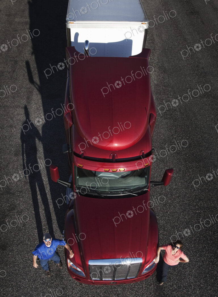 Portrait of a Caucasian husband and wife driving team with their commercial truck.