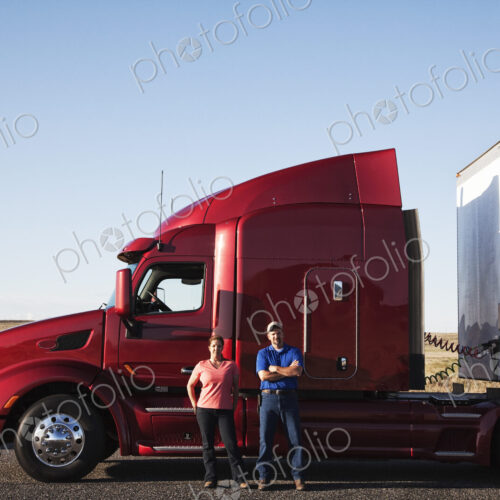 Portrait of a Caucasian husband and wife driving team with their commercial truck. Portrait of a Caucasian husband and wife driving team with their commercial truck.