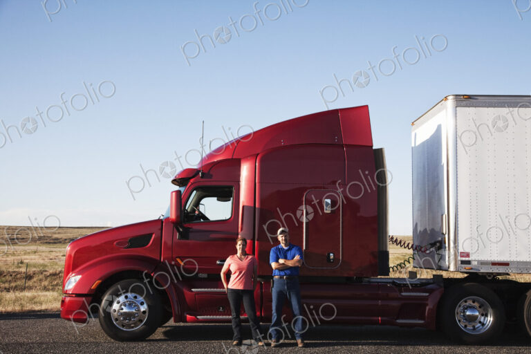 Portrait of a Caucasian husband and wife driving team with their commercial truck.