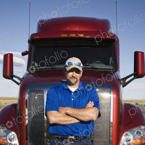 Portrait of a Caucasian man driver and his commercial truck. Portrait of a Caucasian man driver and his commercial truck.