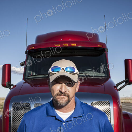 Portrait of a Caucasian man driver and his commercial truck. Portrait of a Caucasian man driver and his commercial truck.