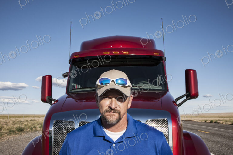 Portrait of a Caucasian man driver and his commercial truck.
