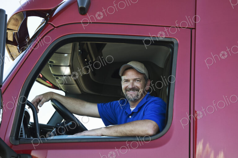 Portrait of a Caucasian man driver and his commercial truck.