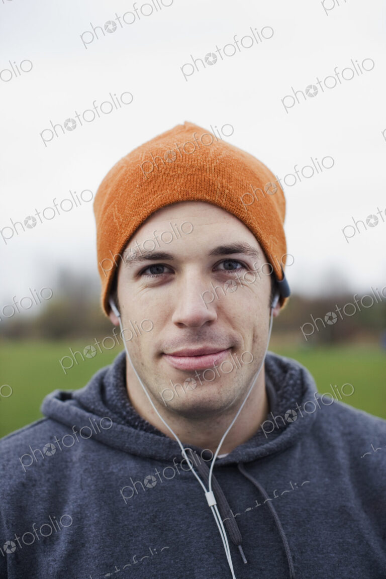Portrait of a Caucasian man in an orange beanie hat.