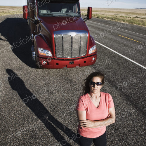 Portrait of a Caucasian woman driver and her commercial truck. Portrait of a Caucasian woman driver and her commercial truck.