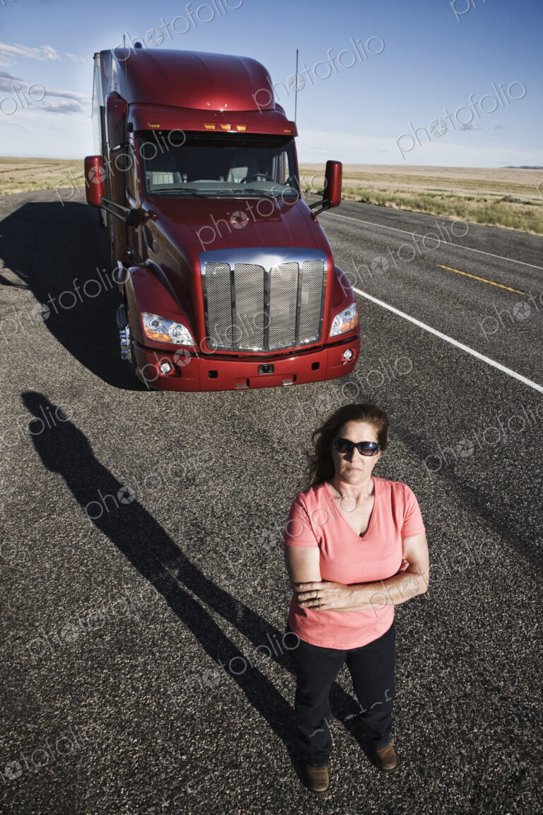 Portrait of a Caucasian woman driver and her commercial truck.