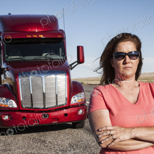 Portrait of a Caucasian woman driver and her commercial truck. Portrait of a Caucasian woman driver and her commercial truck.