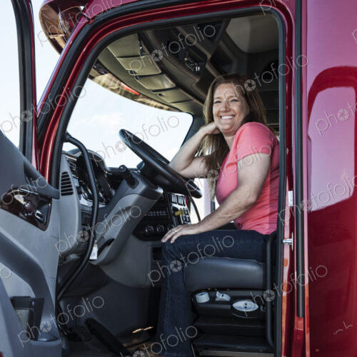 Portrait of a Caucasian woman driver and her commercial truck. Portrait of a Caucasian woman driver and her commercial truck.