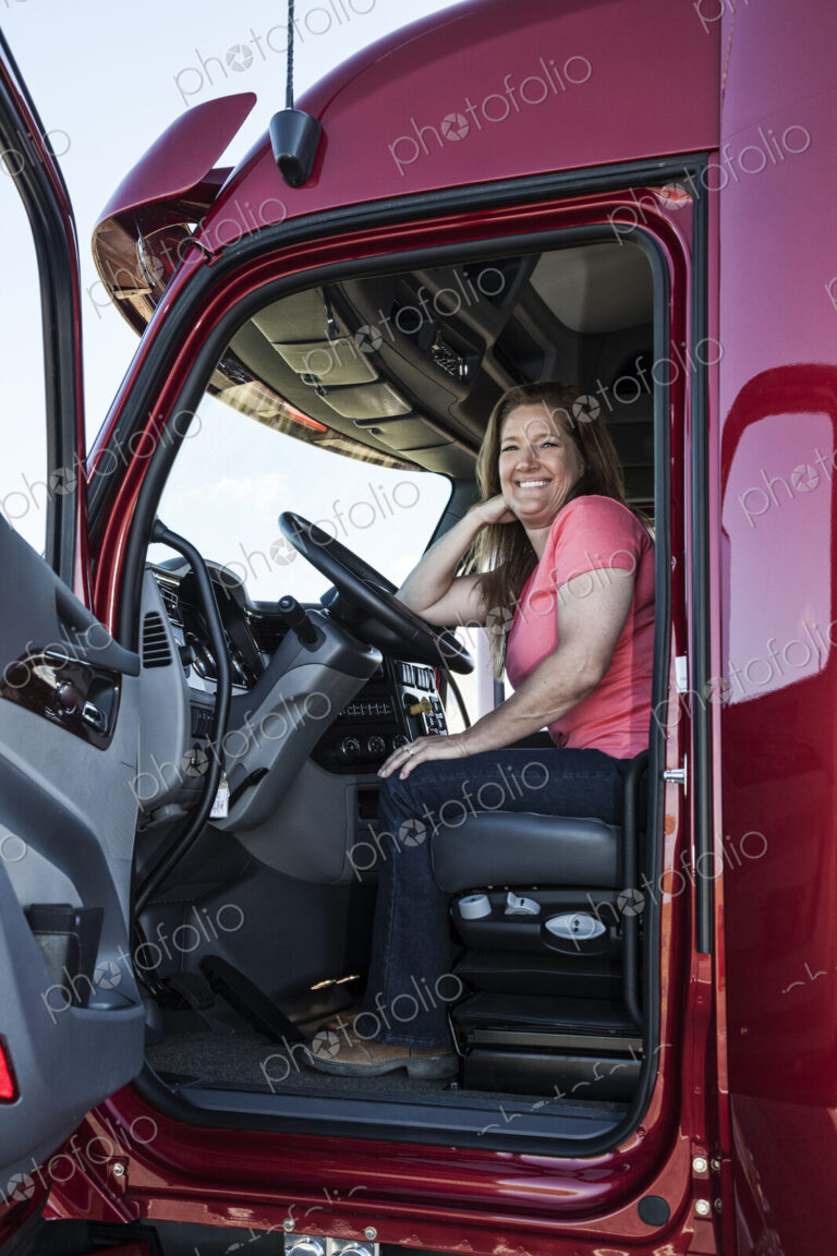 Portrait of a Caucasian woman driver and her commercial truck.