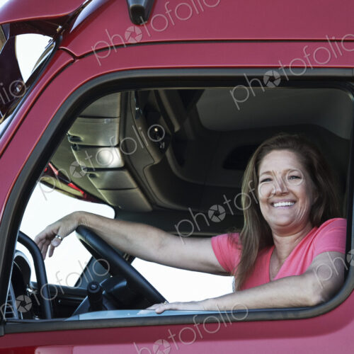 Portrait of a Caucasian woman driver and her commercial truck. Portrait of a Caucasian woman driver and her commercial truck.